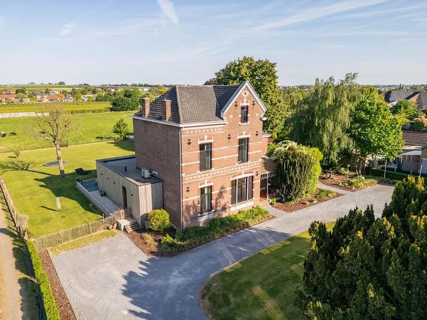 Het domein vanuit de lucht: het herenhuis met de oprit, het gazon en de velden van Haspengouw erachter.