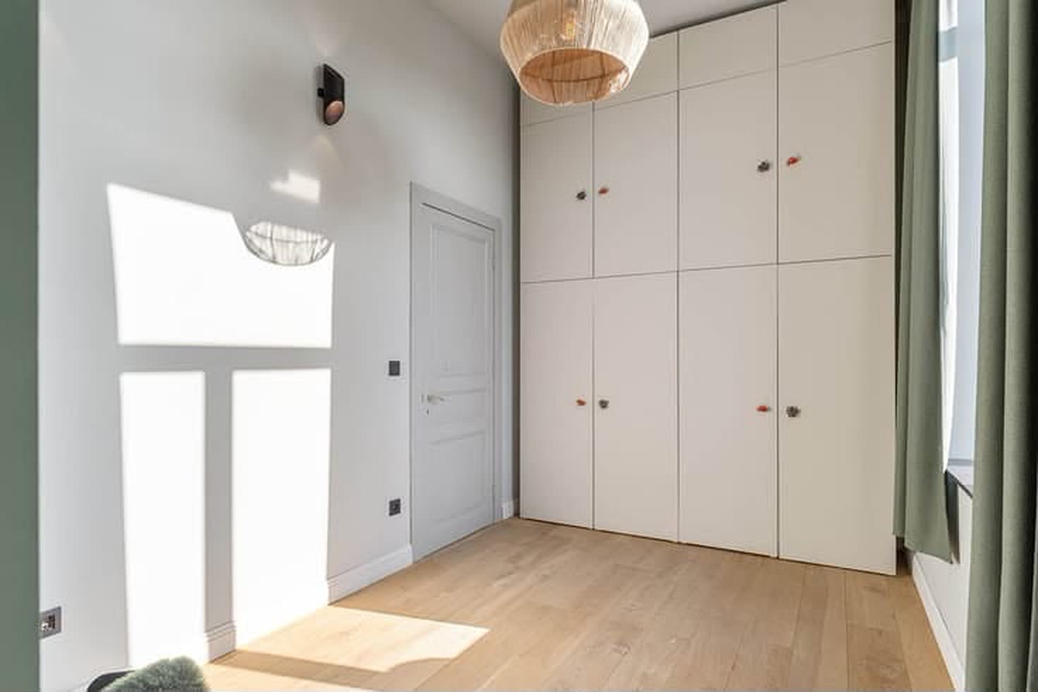 Vestiaire met ingebouwde kastenwand tot aan het plafond en daglicht via de voordeur.