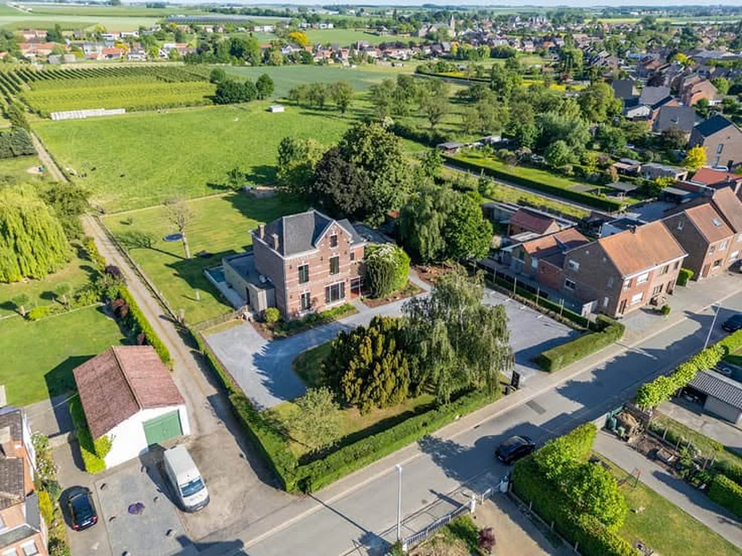 Luchtfoto van Velm met het domein links in beeld, omringd door velden, boomgaarden en de dorpskern.